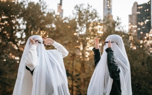 Two people wearing sheet ghost costumes