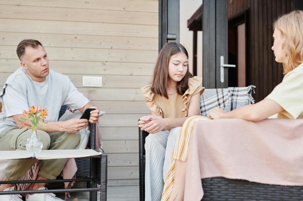 A family sitting on sofa discussing relations