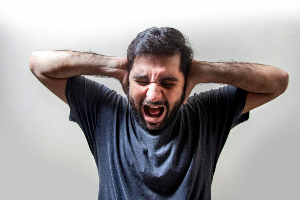 A man shouting and covering his ears at an addiction treatment center Idaho