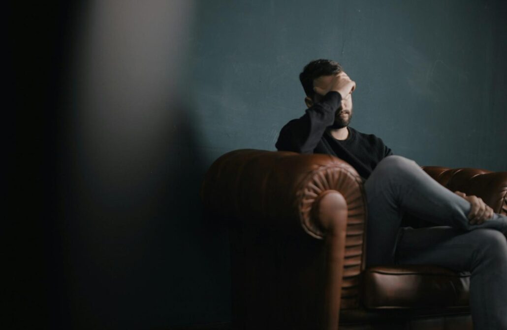 A man covering his face at an addiction treatment center 