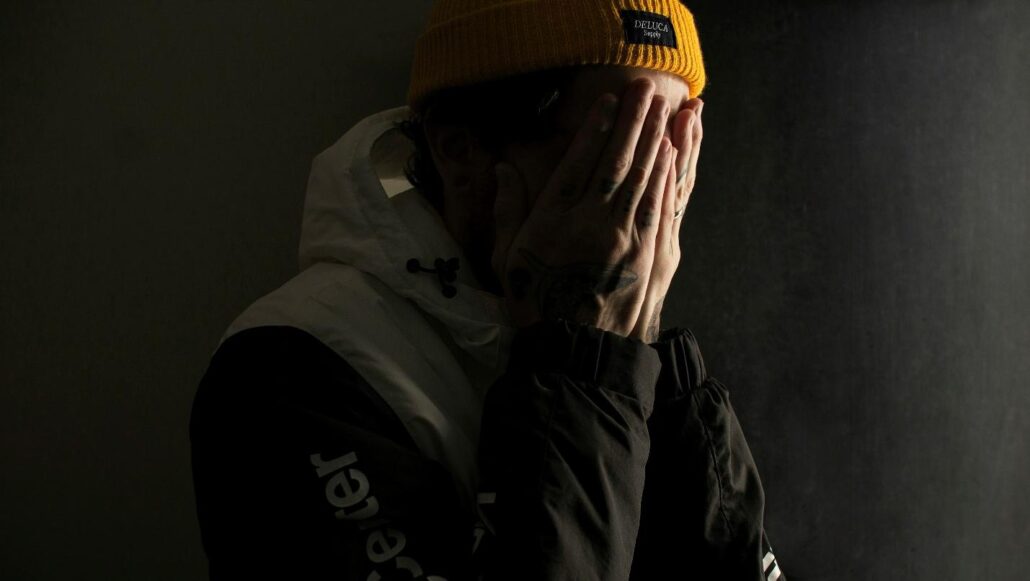 A man covering his face at an addiction treatment center Idaho